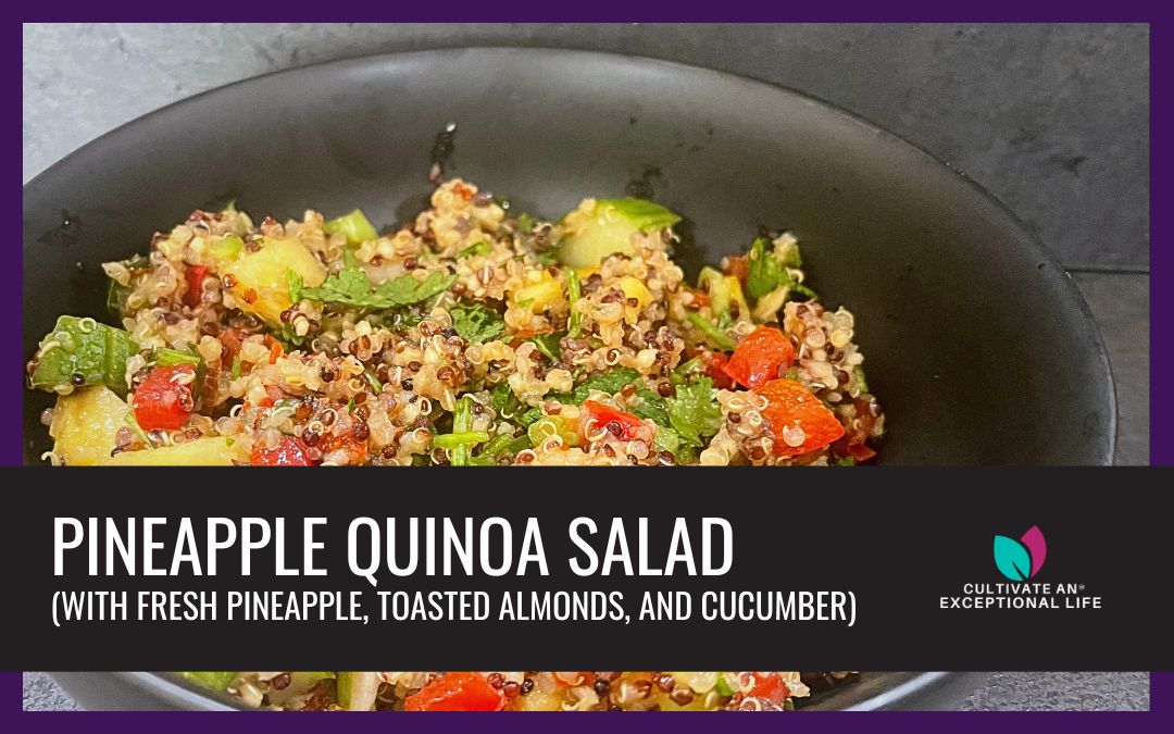 Photo of pineapple quinoa salad in a black bowl.